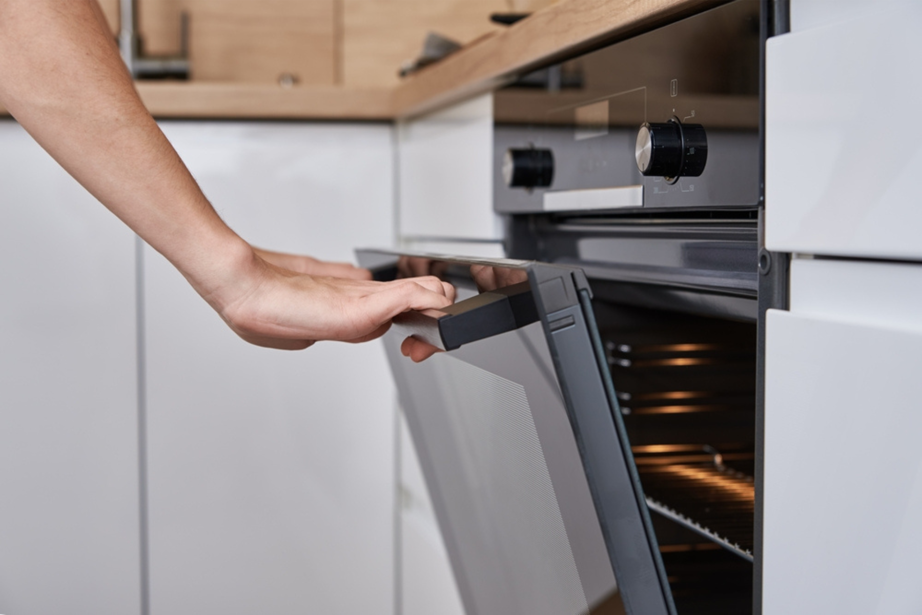 Opening the door of a built-in oven